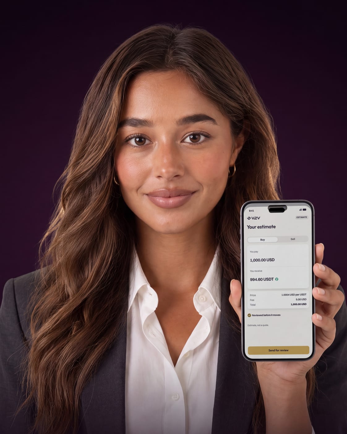 A smiling woman in a charcoal blazer holds up her phone showing a V2V payment order